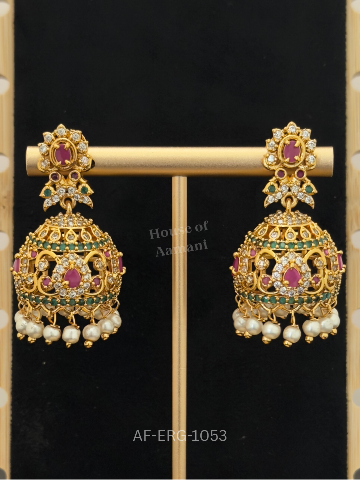 Large cutwork domes with emerald bands and ruby teardrop centres are surrounded by a cascade of white pearls.