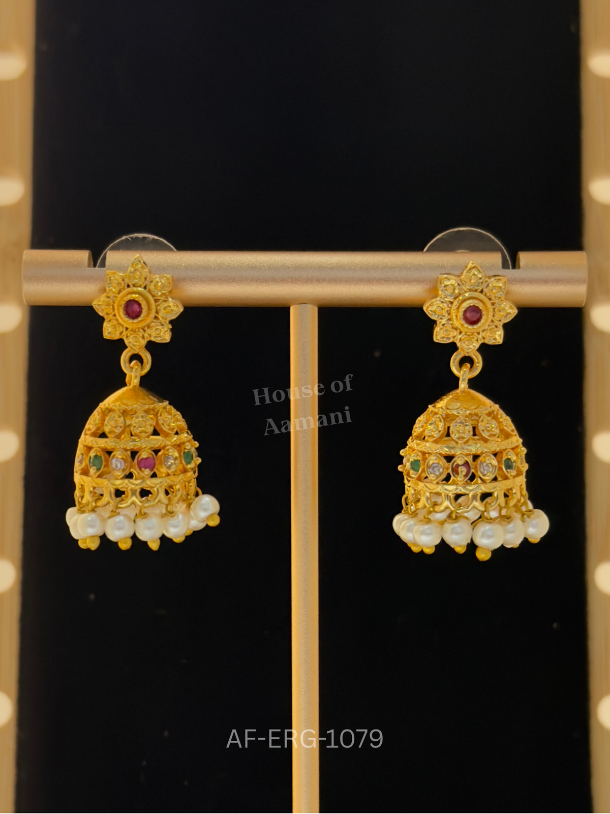 Textured gold star-flower tops with ruby centres lead to small cutwork domes accented with stones and pearls.