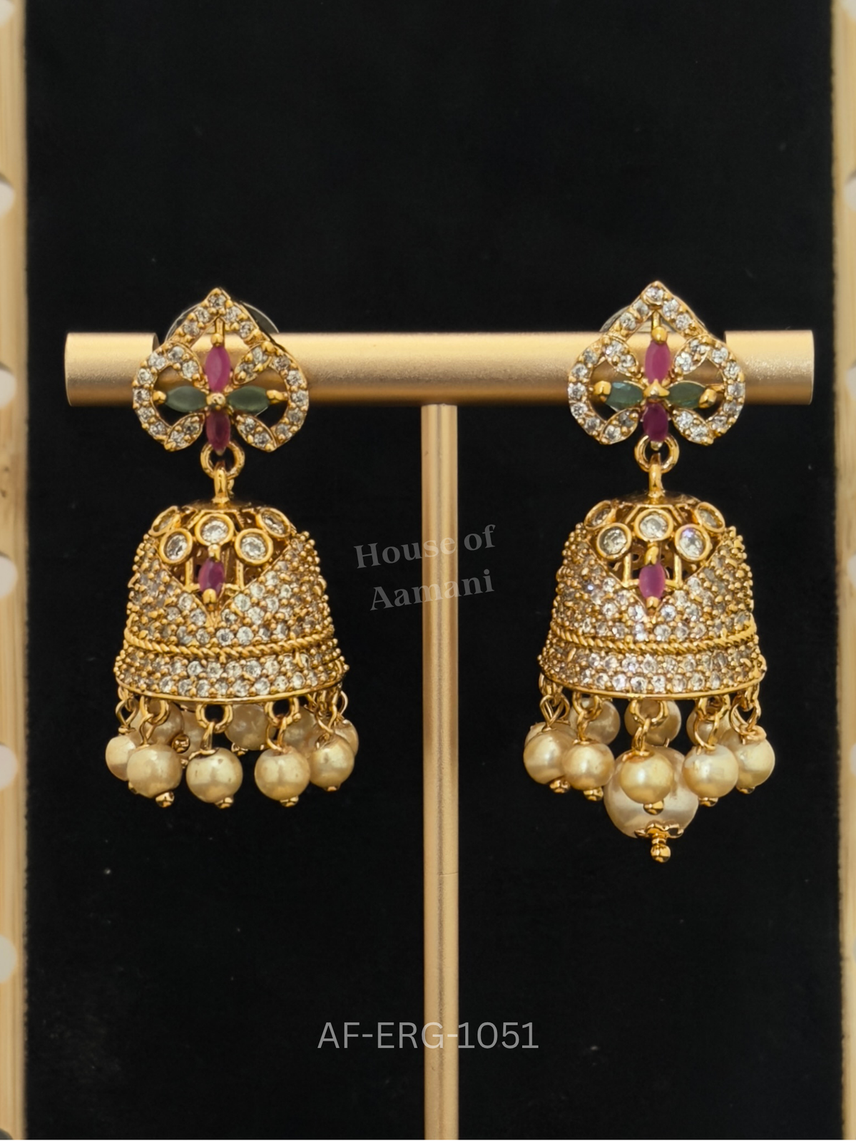 Crystal petal tops with ruby and emerald marquise stones lead to a dazzling bell dome fringed with cream pearls.