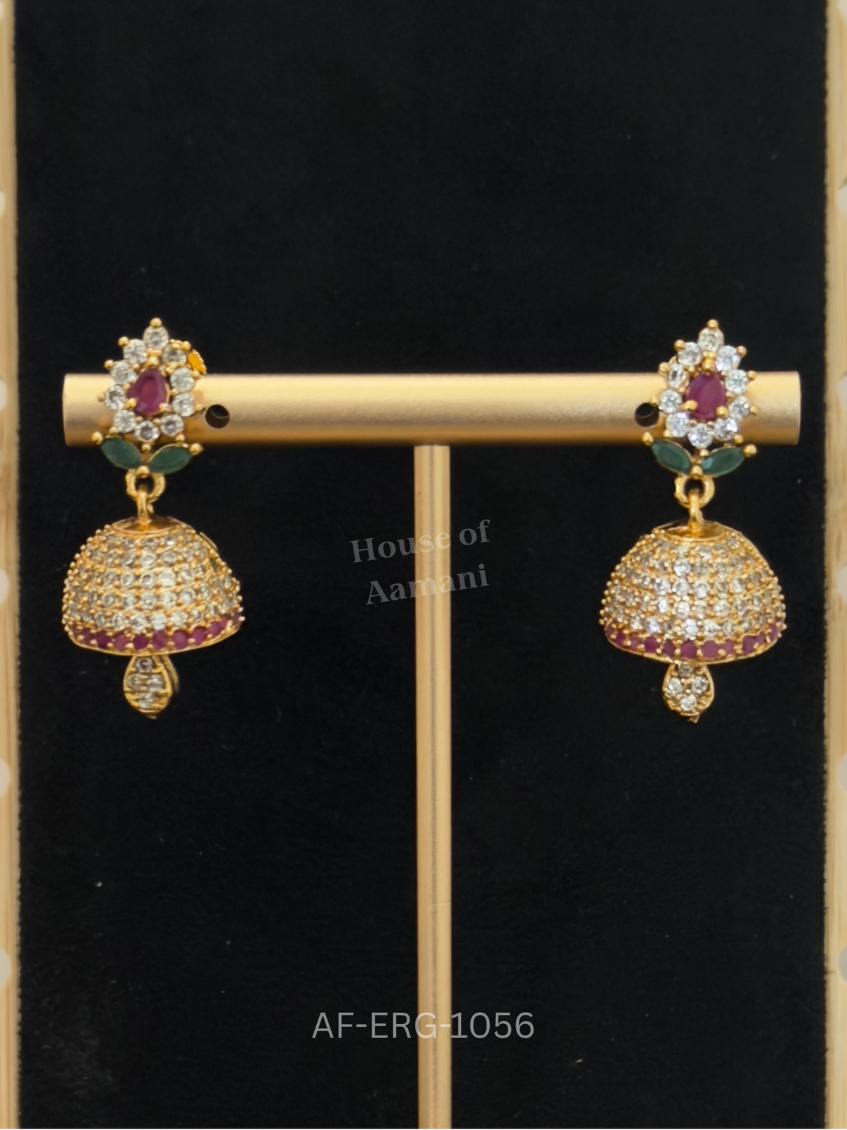 Compact jhumkas with a floral ruby-crystal top and a sparkling crystal dome edged in ruby stones, perfect for everyday elegance.