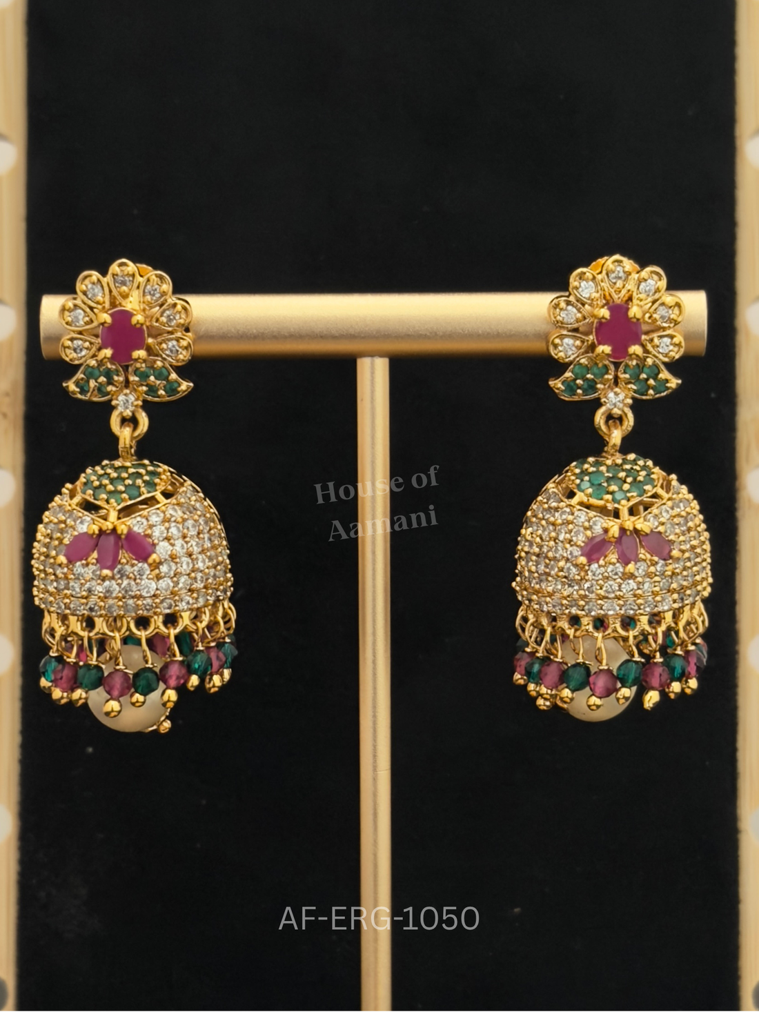 A ruby-centred floral top leads to an emerald-capped crystal dome with a ruby lotus motif and ruby-green bead drops.