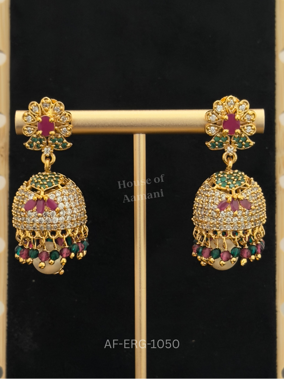 A ruby-centred floral top leads to an emerald-capped crystal dome with a ruby lotus motif and ruby-green bead drops.