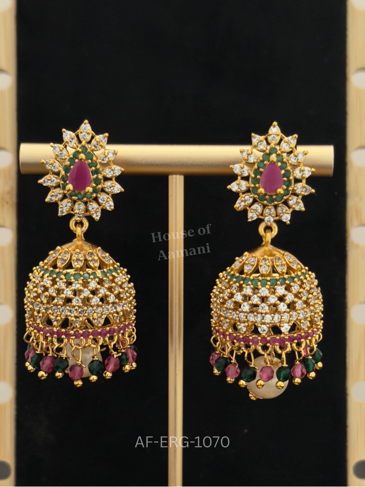 Statement jhumkas with a sunburst top and a sparkling crystal lattice dome banded in emerald and ruby, with bead and pearl drops.