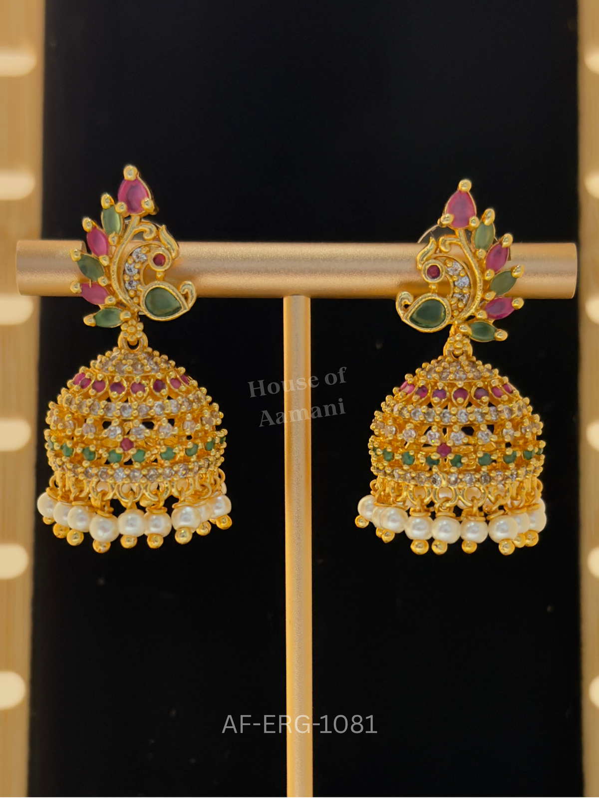A peacock plume top of ruby and emerald marquise stones leads to a sparkling crystal dome with a pearl fringe.