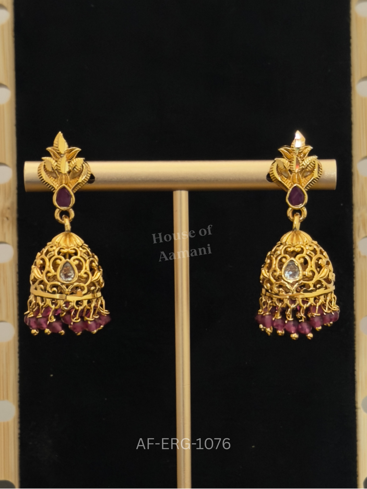 Antique gold leaf tops lead to intricate filigree domes with a clear stone centre and a fringe of ruby beads.