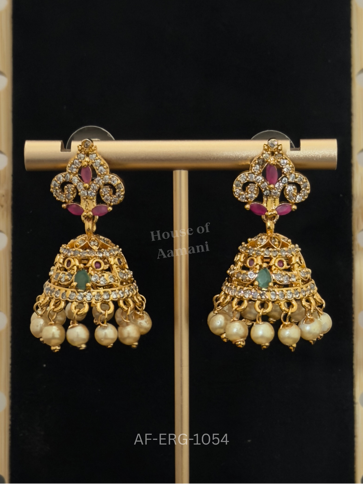 A crystal fleur-inspired top with ruby marquise stones leads to a tiered bell dome with pearl drops.