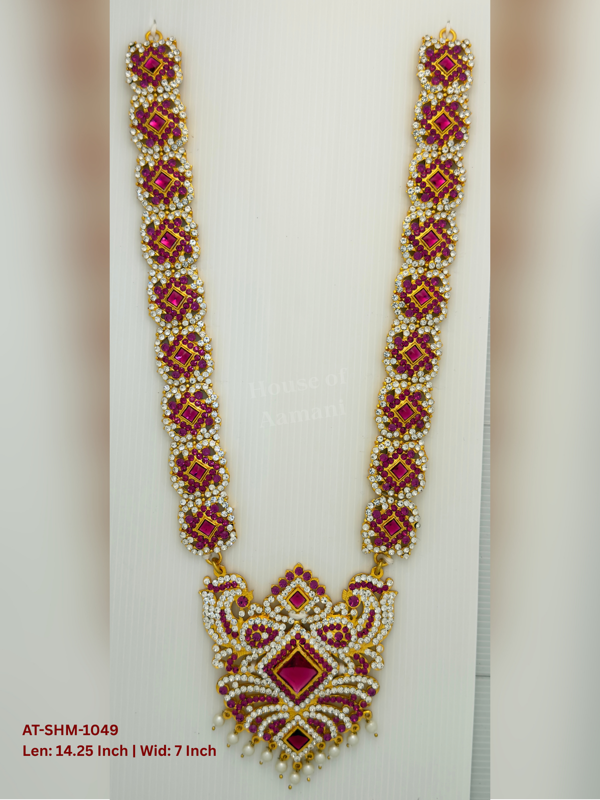 Elevate your deity alankaram with our traditional gold-plated 14.25-inch Swamy Haram with Fuchsia Pink, White Coloured Stones.
