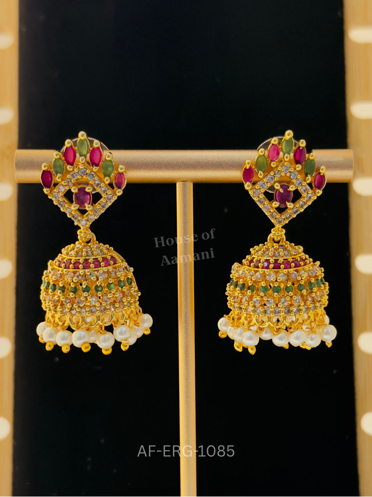 A ruby and emerald marquise crown over a crystal diamond frame leads to a jewelled dome with a fringe of white pearls.