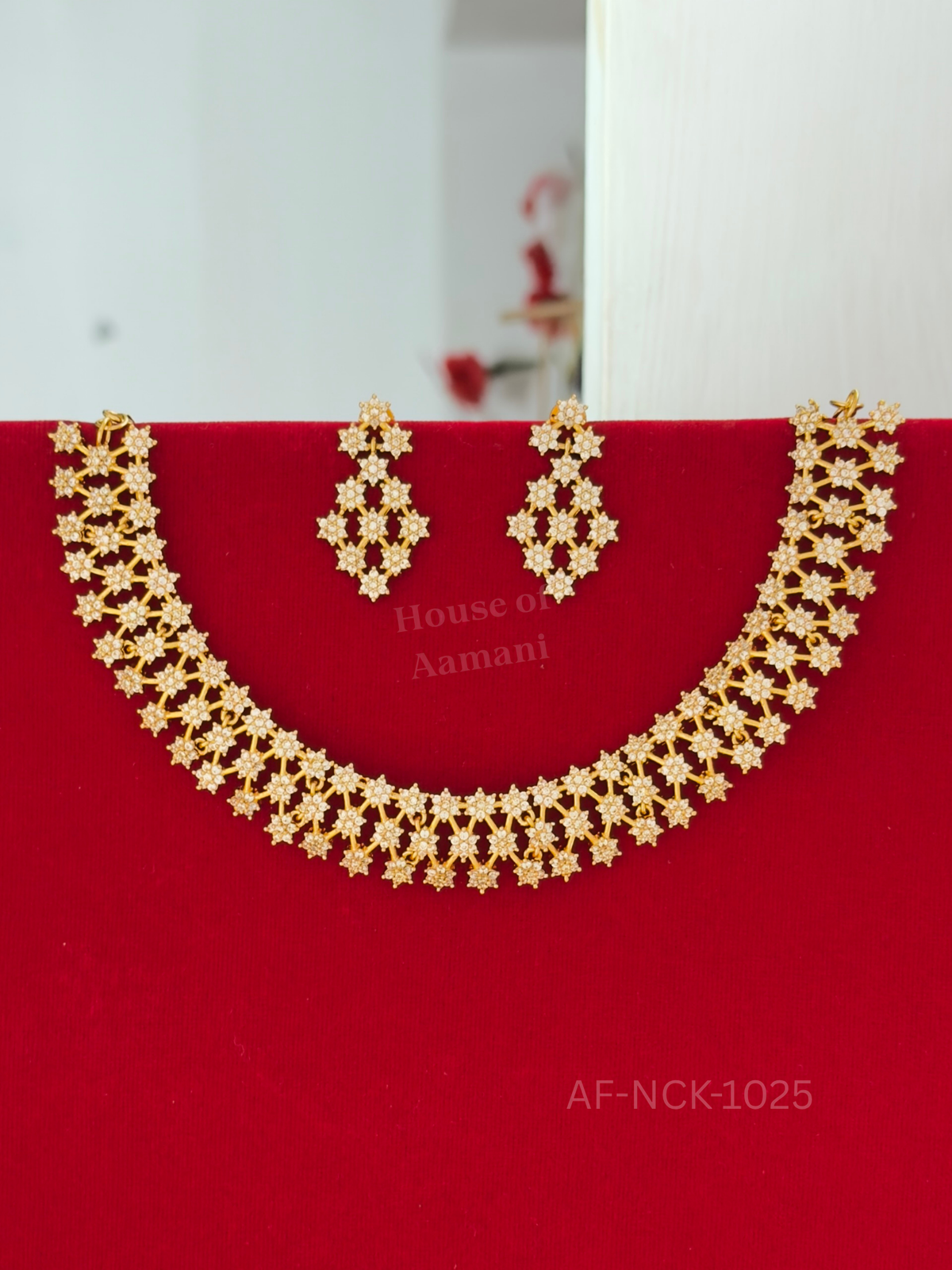 A shimmering lattice choker of star-shaped white crystal flowers, completed with matching chandelier earrings.