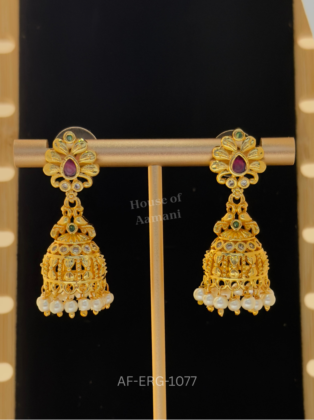 Petal-shaped tops with a ruby teardrop lead to intricate golden cage domes with stone accents and pearl drops.