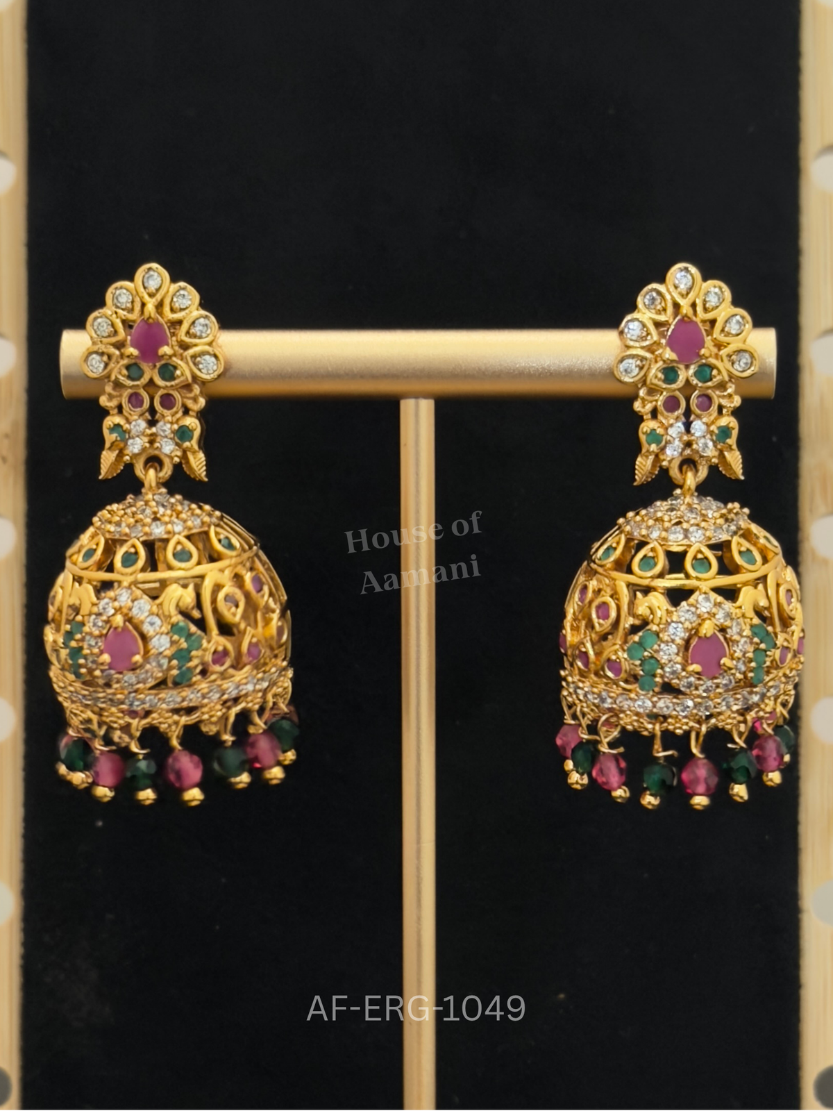 Ornate cutwork domes with peacock motifs are set with ruby, emerald, and crystal stones and tipped with colourful beads.