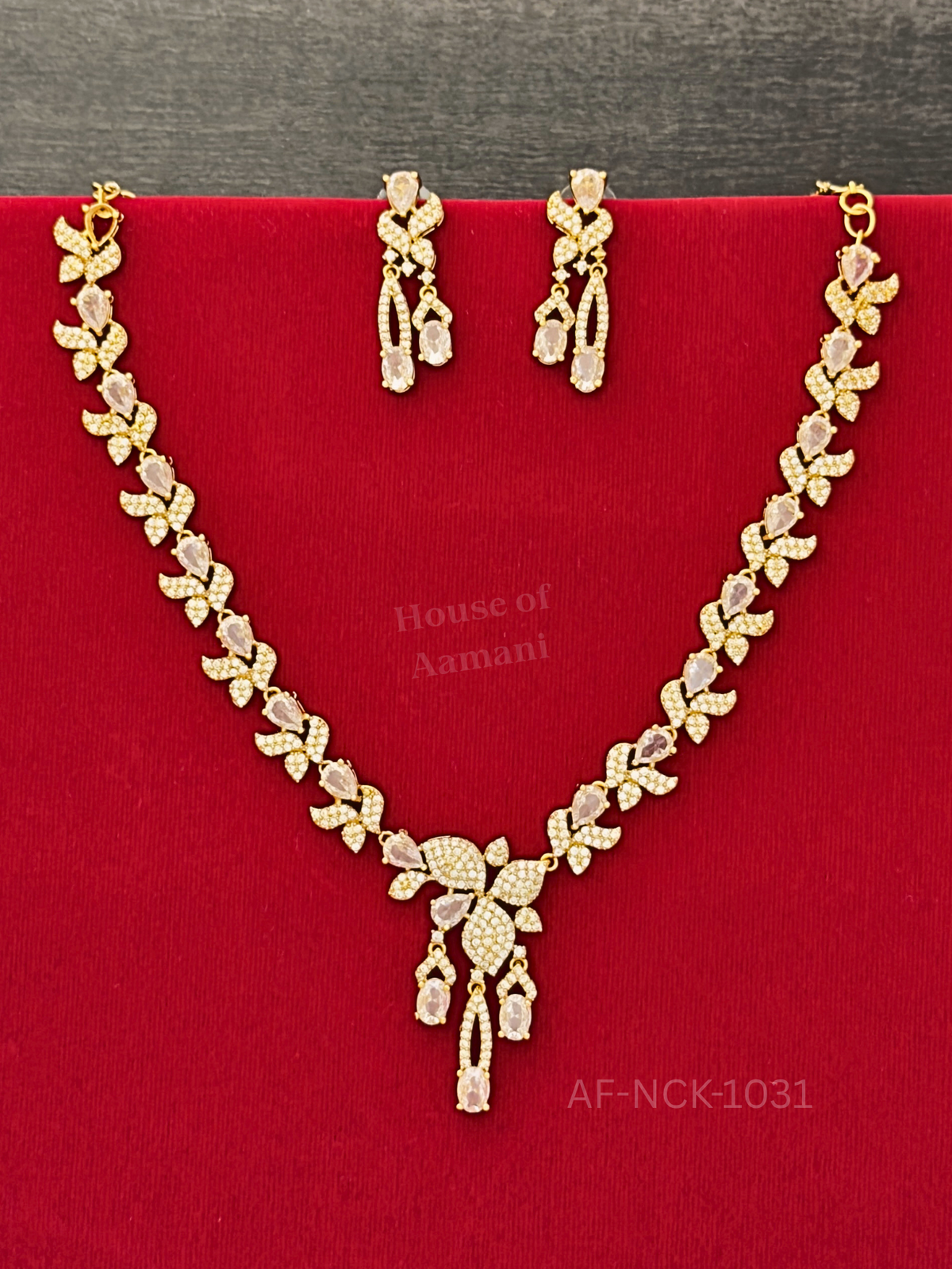 Sparkling white crystal leaves and pear-shaped stones flow into a cascading centre pendant, with matching drop earrings.