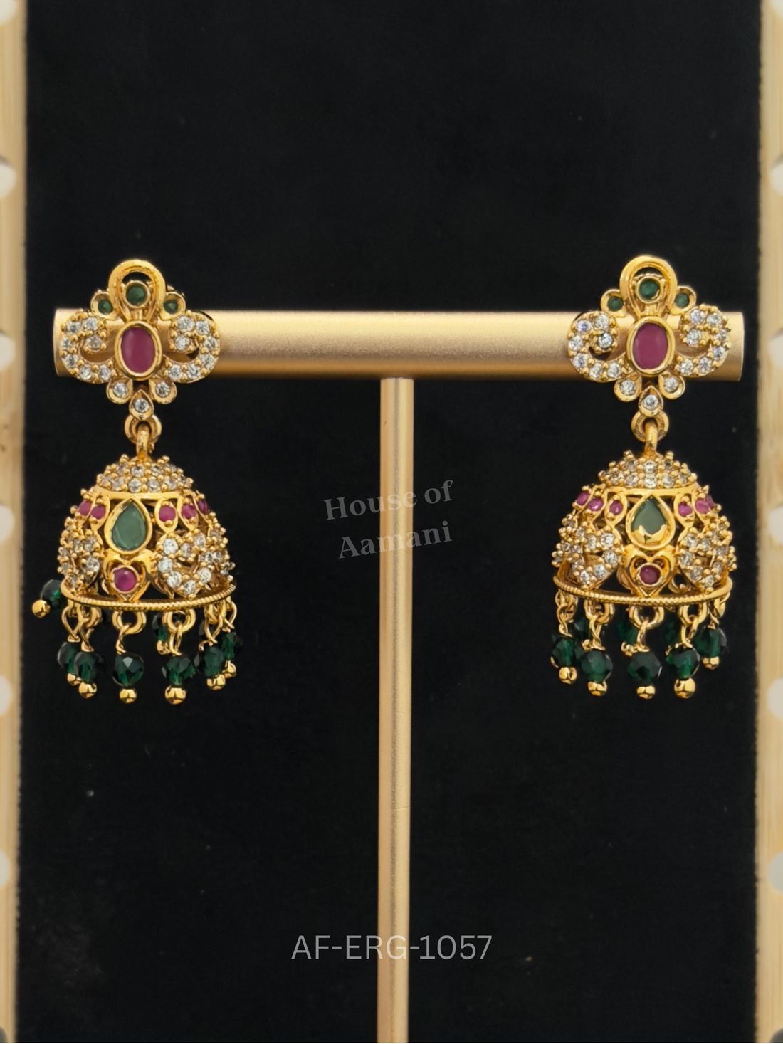 Scrollwork tops with a ruby centre lead to a jewelled dome with emerald teardrops and green bead drops.