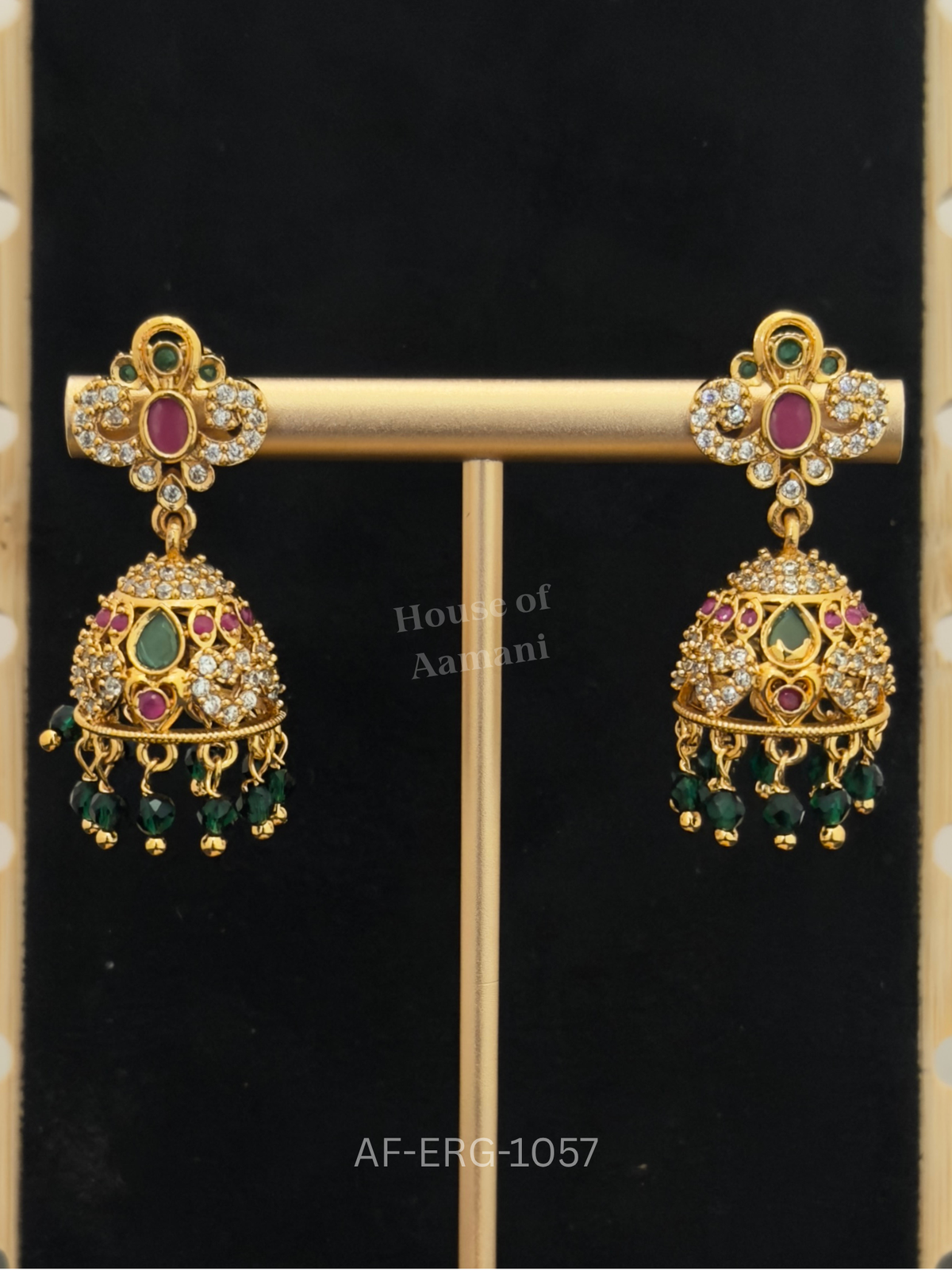 Scrollwork tops with a ruby centre lead to a jewelled dome with emerald teardrops and green bead drops.