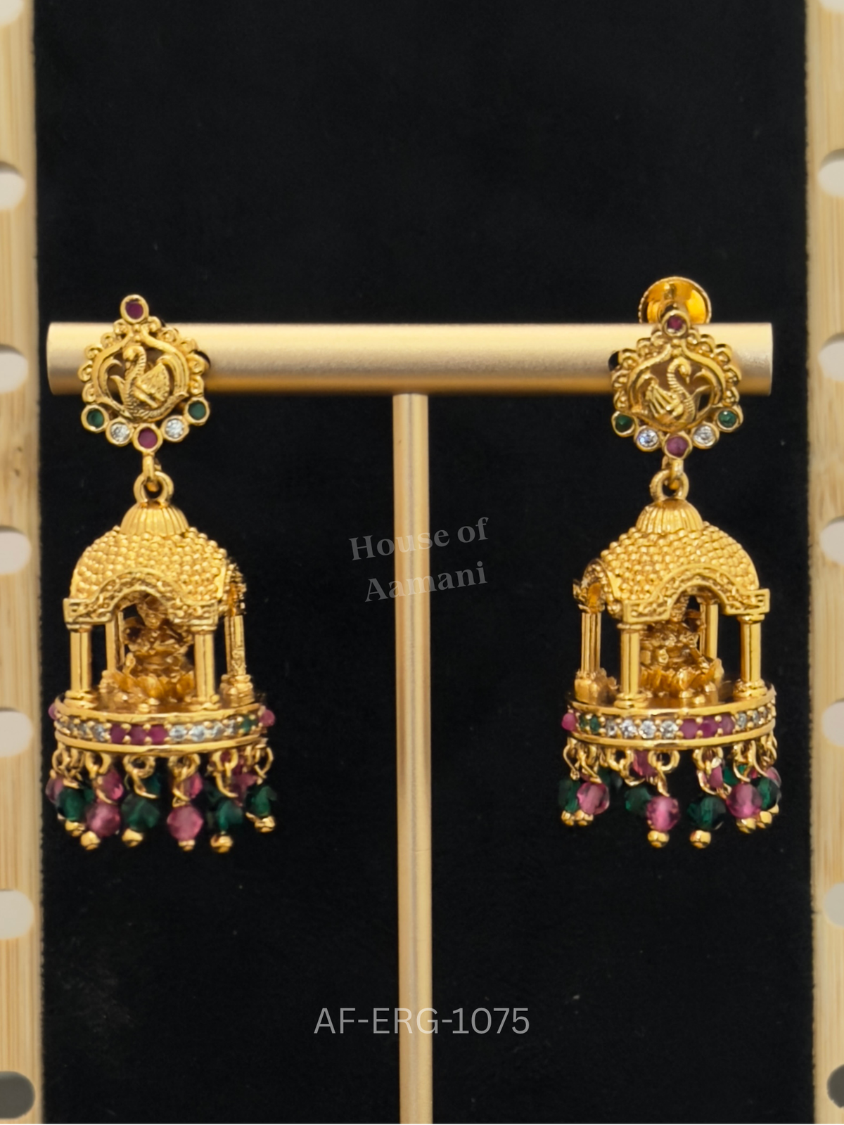 Temple-style jhumkas with swan-motif tops and a pillared pavilion dome housing Goddess Lakshmi, finished with ruby-green beads.
